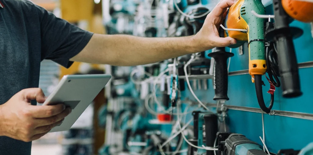Image for Specialty Hardware post, man grabbing a tool while holding a tablet
