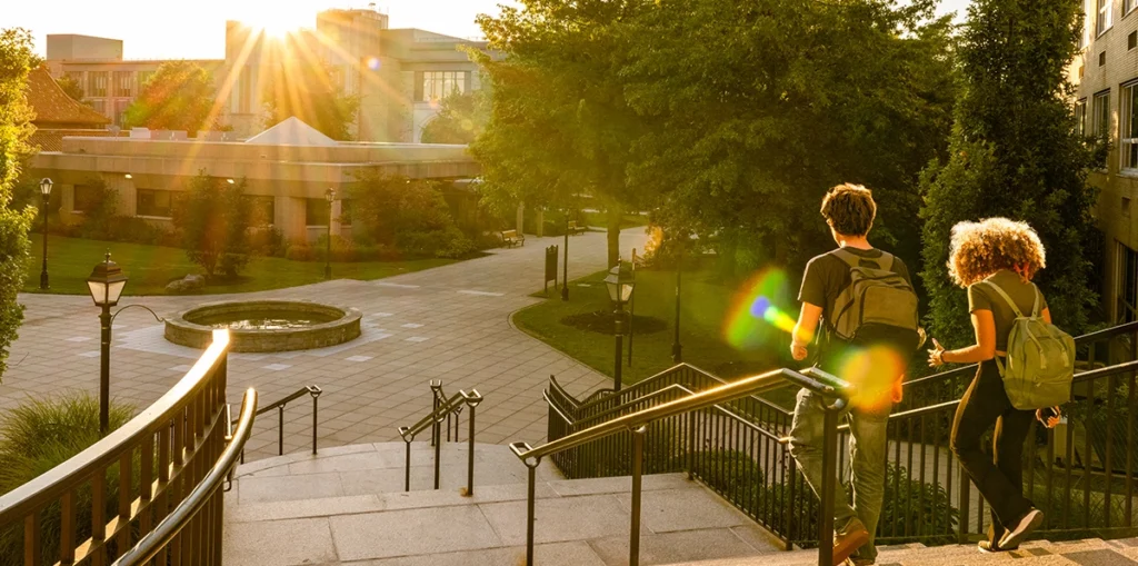 Image of a higher education place with students walking down stairs.