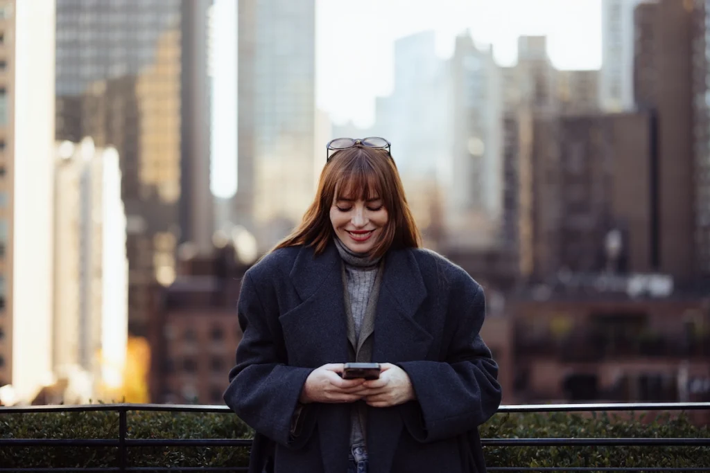 Emotional intelligence in marketing - woman on phone with cityscape behind her