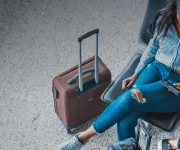 Two women waiting in airport with luggage.